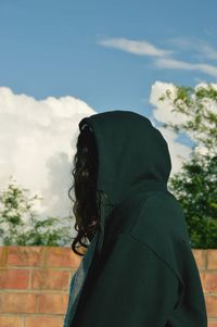 Portrait of woman standing against sky