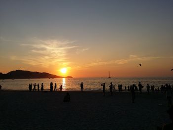 Tourists on beach during sunset