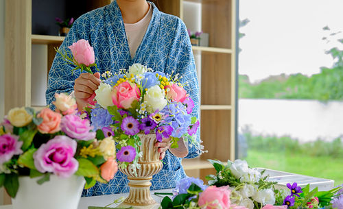 Midsection of woman holding flower bouquet