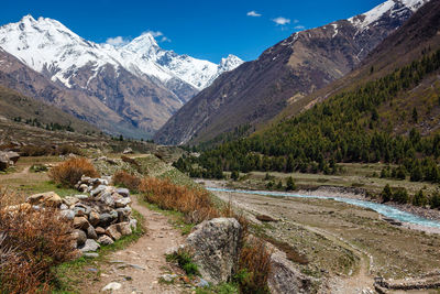 Scenic view of stream by mountains against sky