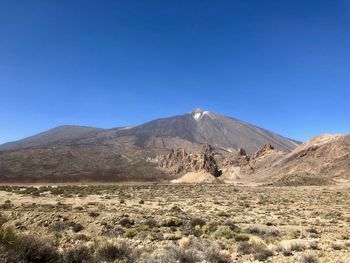 Scenic view of mountains against clear blue sky