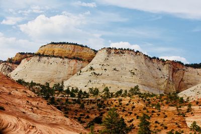 Rock formations on landscape against cloudy sky