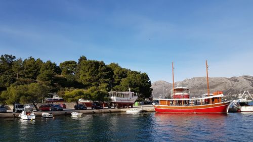 Boats moored in river against sky