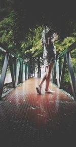 Woman walking on footbridge