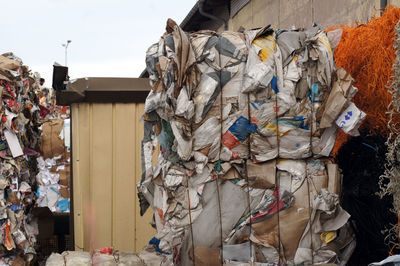 Stack of garbage by metal structure against sky