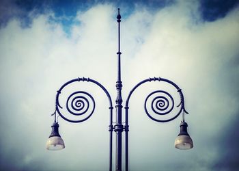 Low angle view of street light against cloudy sky