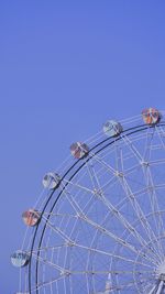 Low angle view of ferris wheel against clear blue sky