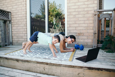 Side view of mother and daughter exercising outdoors