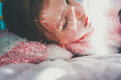 Close-up portrait of woman lying down in snow