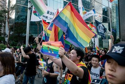 Group of people on street against buildings in city