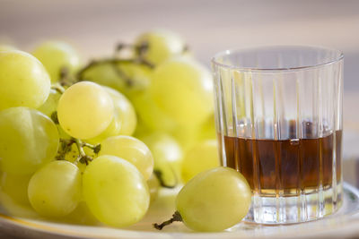 Close-up of grapes and drink in plate