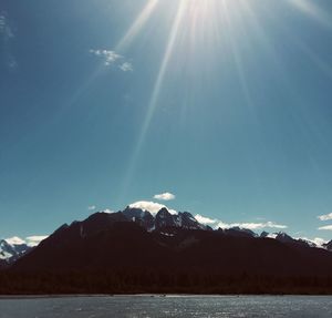 Scenic view of snowcapped mountains against sky on sunny day