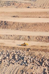 Drone shot of construction vehicle on dirt land