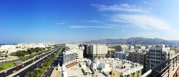 High angle view of buildings in city against blue sky