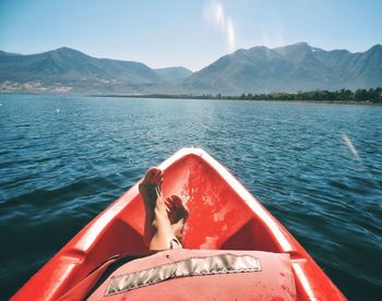 Boat sailing on sea against mountains