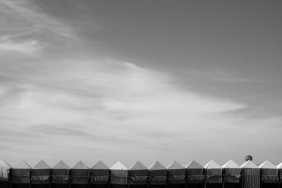 Beach huts in row against sky