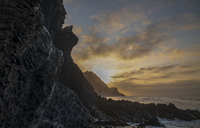 Rock formations in sea in cabo de gata nature park, spain, against sky during sunrise