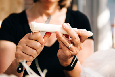 Midsection of woman cutting vegetable