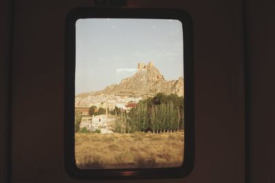 View of residential buildings through window
