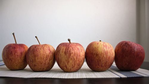 Close-up of fruits on table against wall