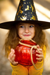 Portrait of girl holding glass jar during halloween