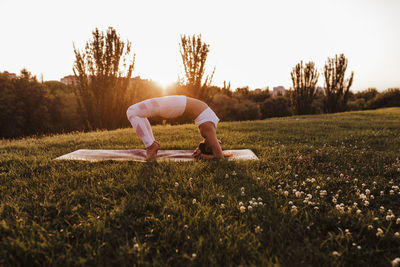 Woman with arms raised on field against sky