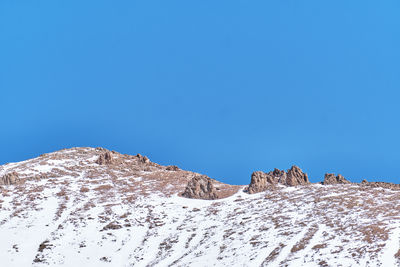 Low angle view of mountain against clear blue sky