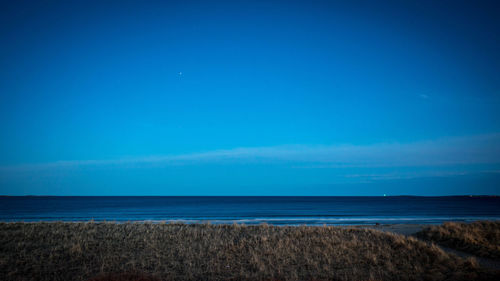 Scenic view of sea against clear blue sky