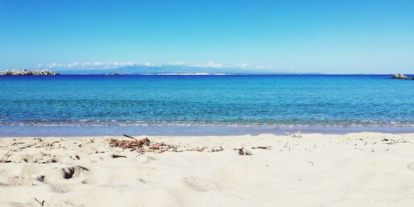 Scenic view of beach against blue sky