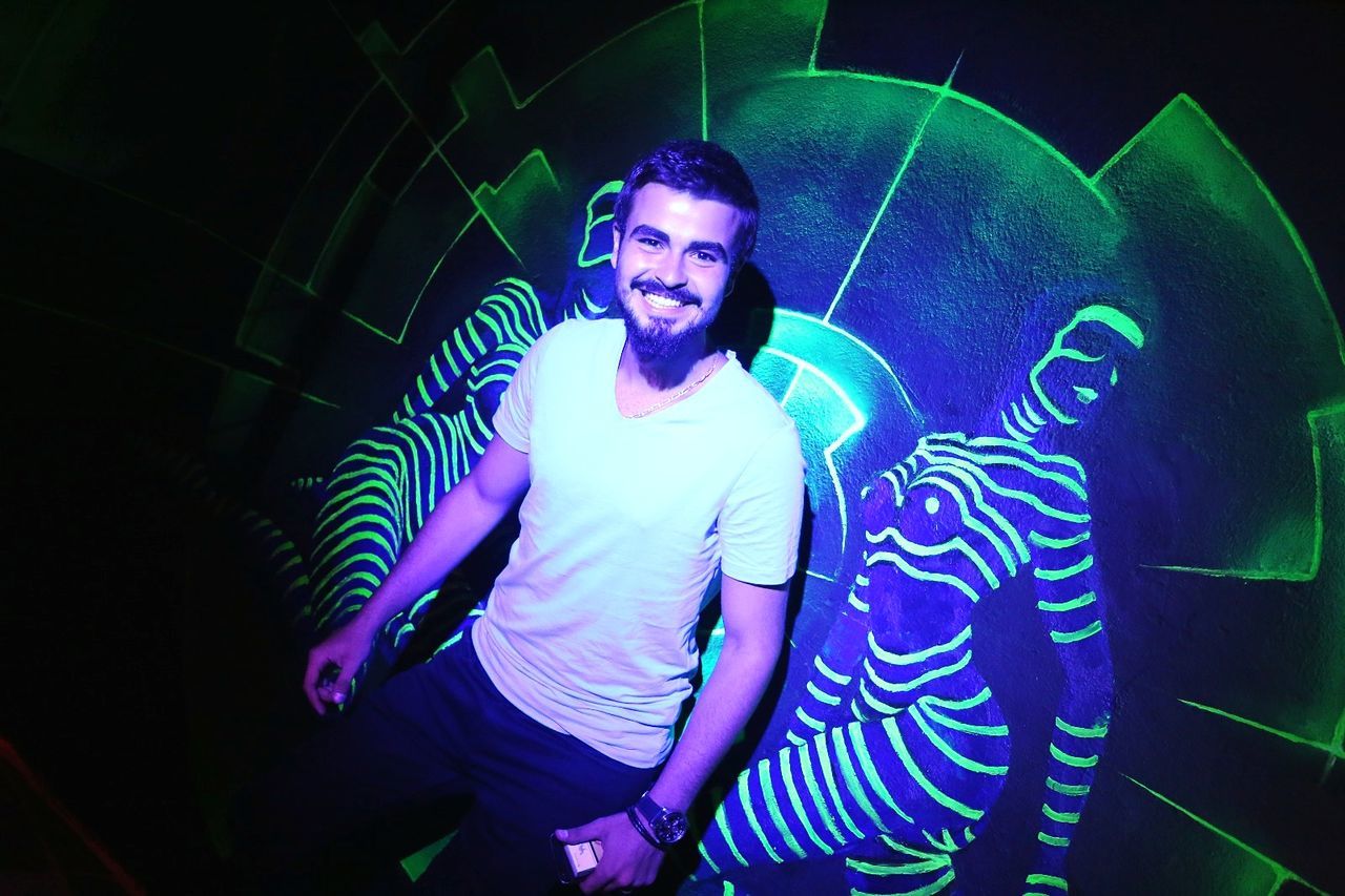 night, looking at camera, arts culture and entertainment, illuminated, one person, real people, fun, indoors, portrait, nightlife, lifestyles, enjoyment, leisure activity, happiness, dj, blue, music, clubbing, party - social event, nightclub, fish-eye lens, smiling, young adult, disco lights, neon, people
