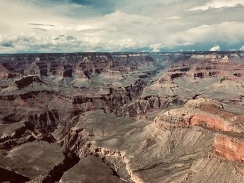 Aerial view of dramatic landscape against cloudy sky