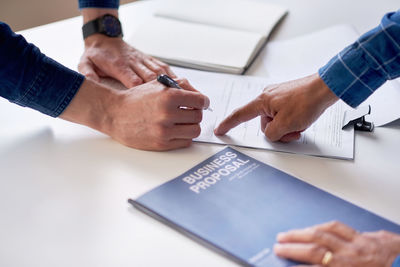 Cropped hands of business colleagues working on table