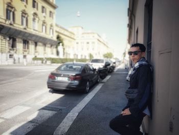 Side view of man standing on street in city