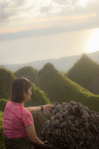 Woman looking at mountains against sky