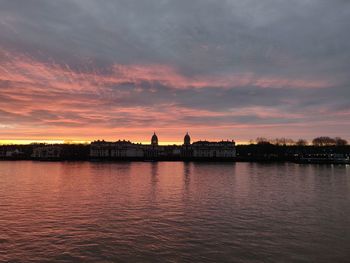 Reflection of buildings in river during sunset