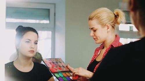 Beautician doing make-up of woman