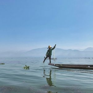 Man surfing in sea against clear sky