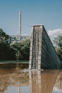 Low angle view of building by lake against sky