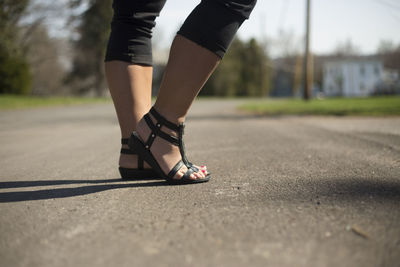 Low section of woman standing on road