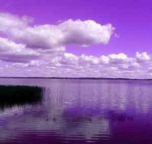 Scenic view of calm lake against blue sky