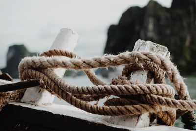 Close-up of rope tied to bollard at harbor