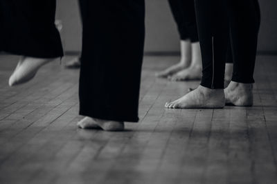 Low section of women standing on tiled floor