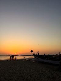 Scenic view of beach against clear sky during sunset