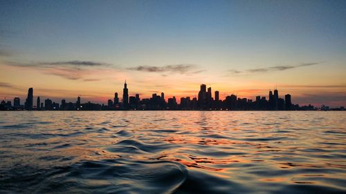 Silhouette buildings against sky during sunset in city