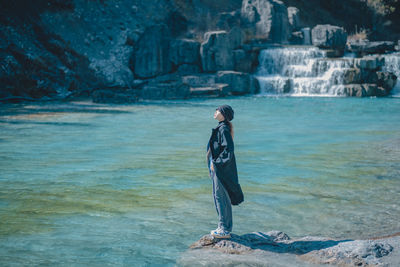 Rear view of woman standing in sea