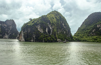 Panoramic view of sea by mountains against sky