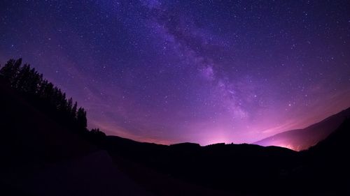 Scenic view of silhouette mountain against star field