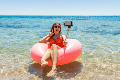 Portrait of young woman in sea against sky