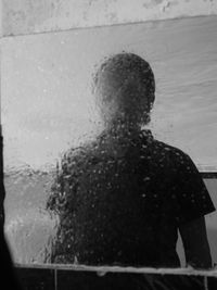 Rear view of woman standing by window