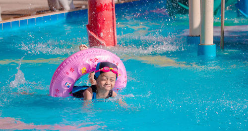 Cute girl standing in swimming pool